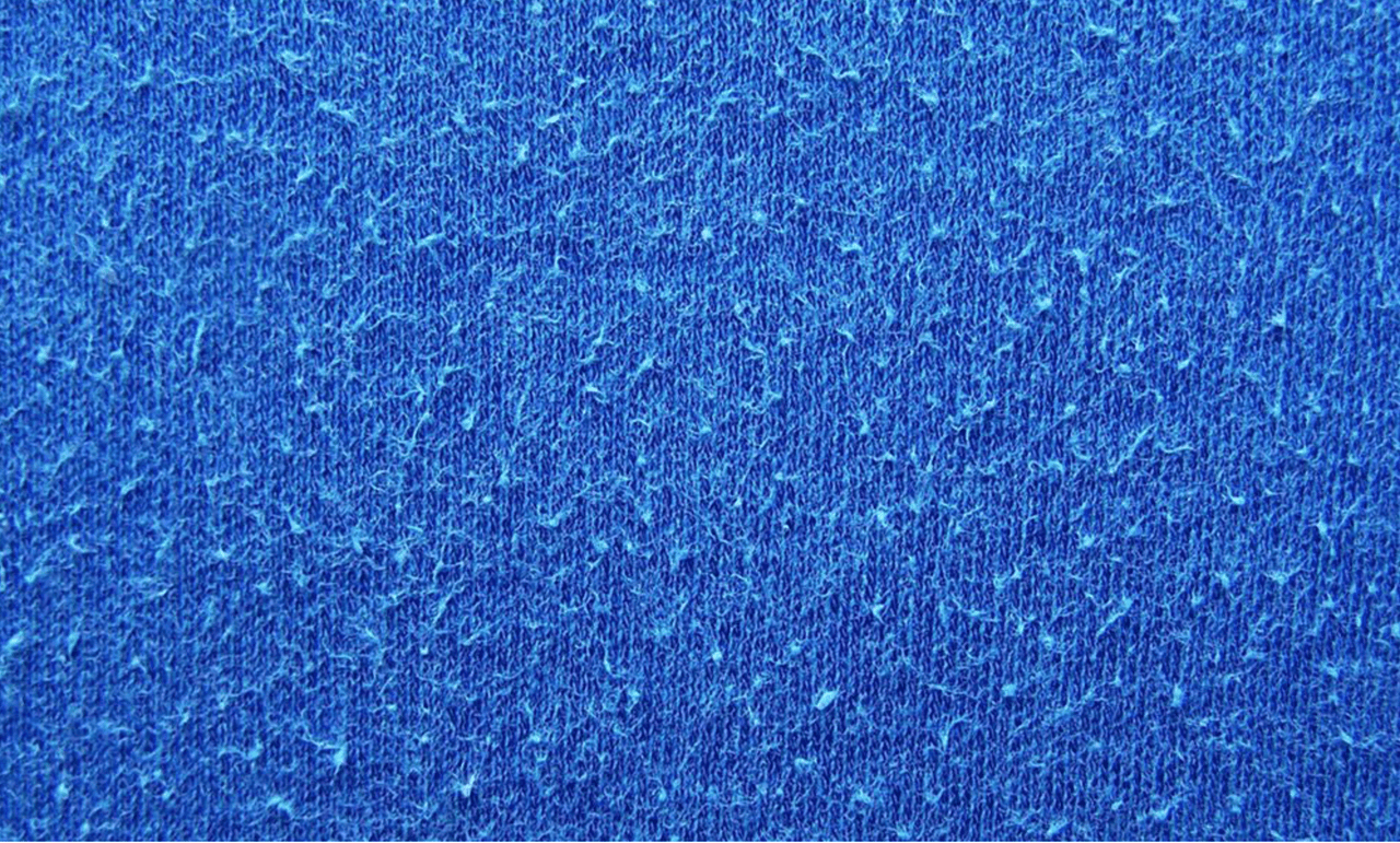 macro photo of pilling blue fabric