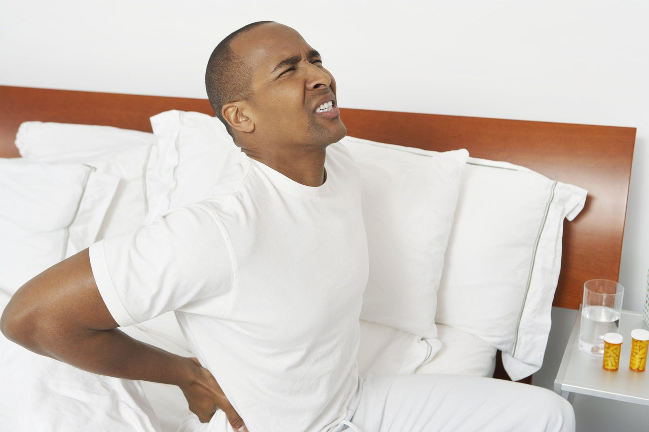 man stretching his back in pain