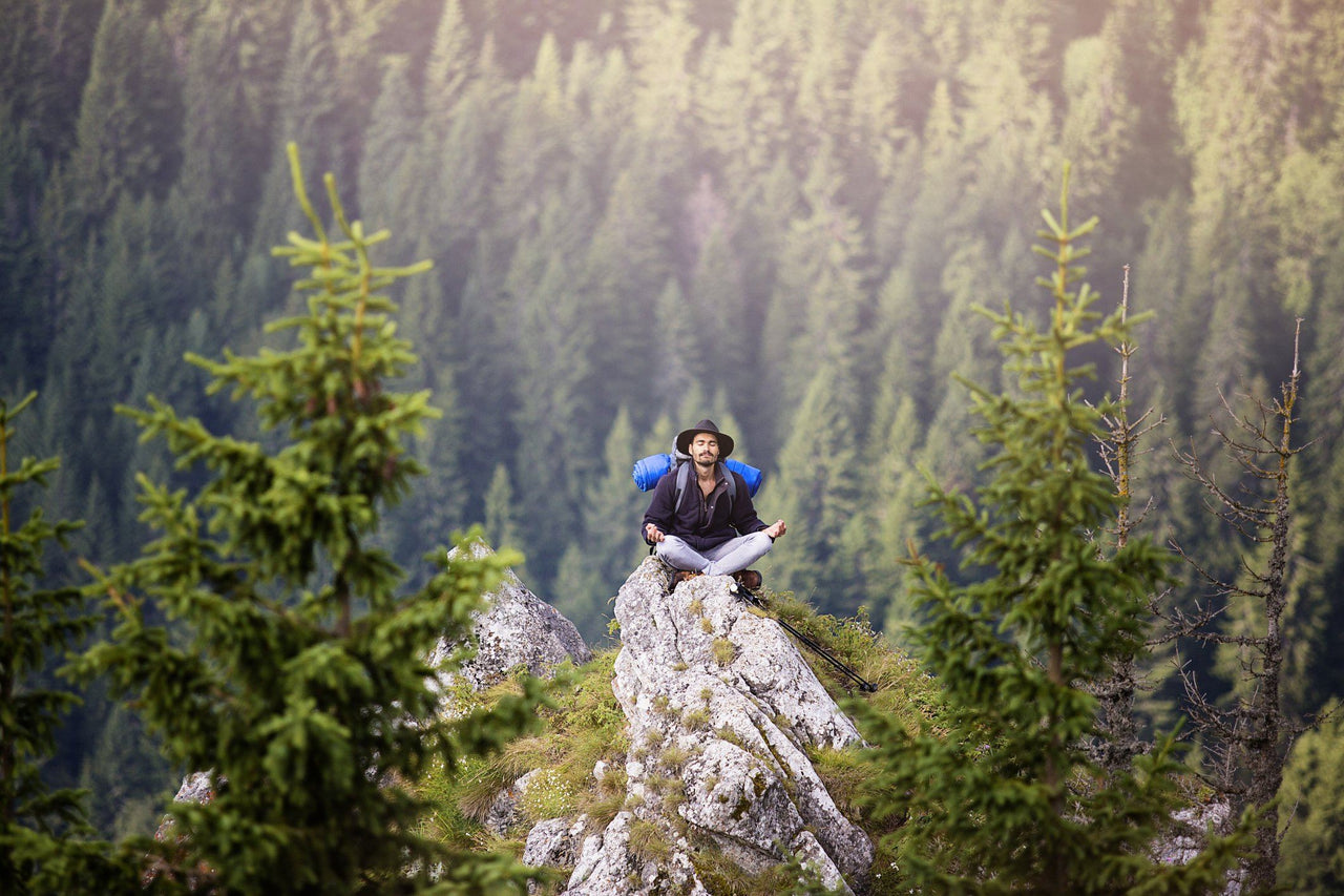 hiker meditating on rock to calm racing thoughts at night