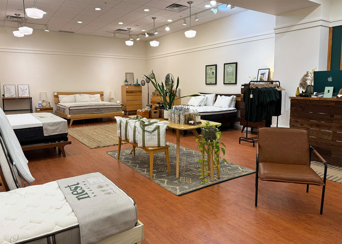 The inside of the Nest Bedding Chico, California store with various beds, chairs, and decor items on a wooden floor.