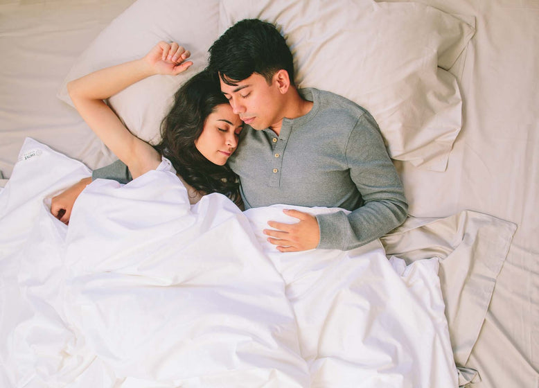 couple in bed with silk comforter