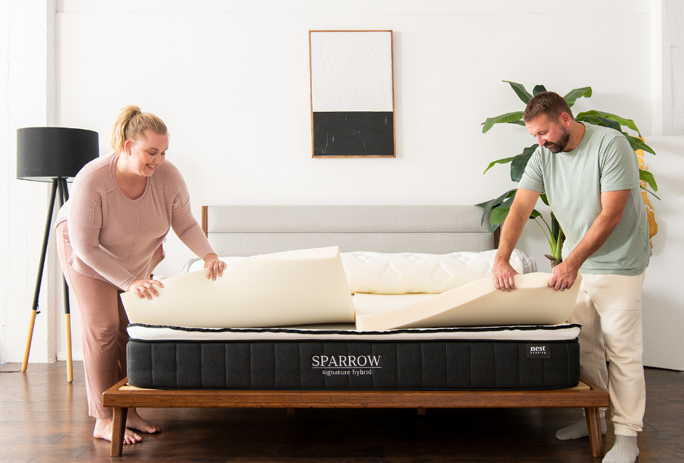 A man and woman opening up the Sparrow mattress to reveal the layers inside the mattress.