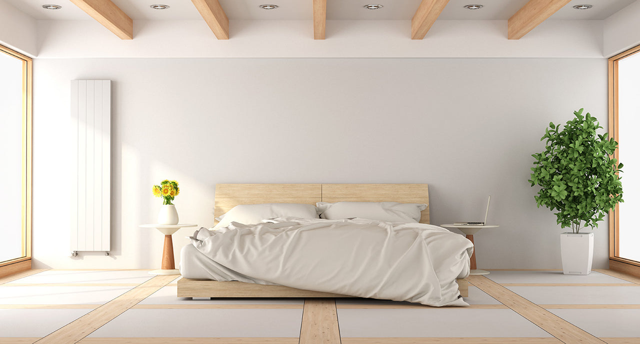 large white and airy bedroom with natural wood accents a bed in the center