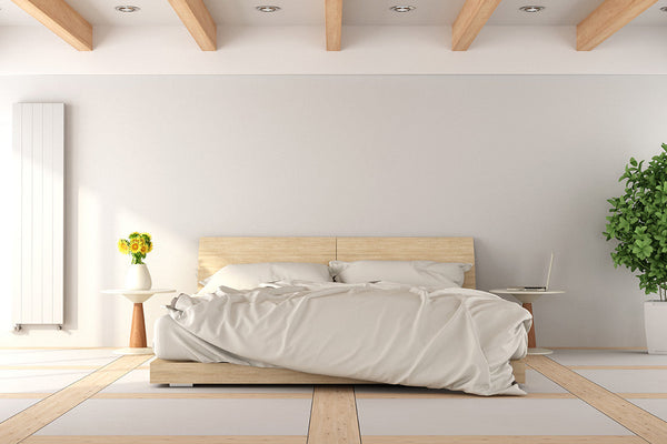 large white and airy bedroom with natural wood accents a bed in the center