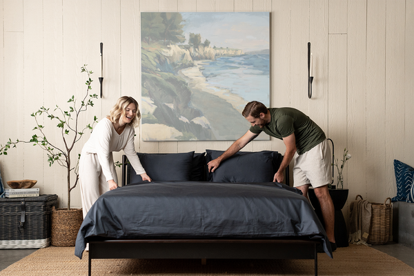 couple making bed, dark grey bedding, slate organic cotton sateen, bed set, duvet set, sheet set, bedroom scene