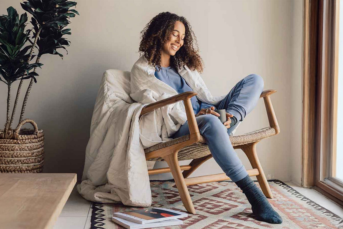 Woman reading in chair looking cozy and comfy