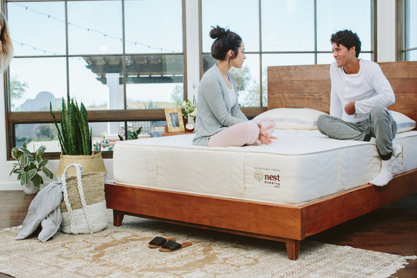 Couple sitting on a Nest mattress in bed