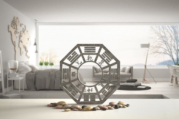 Feng Shui Bagua with pebbles in front of minimalist bedroom