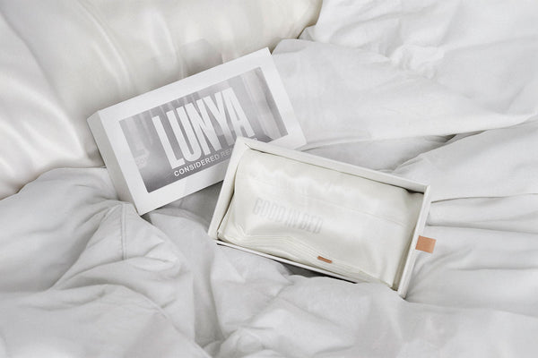 LUNYA branded product packaging on a white bedding