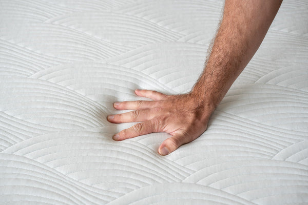 a man's hand pushing into the starling mattress thermic phase change cover