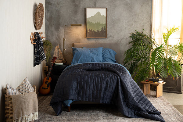 Bright teen bedroom with moody bedding, a guitar, books, and morning light