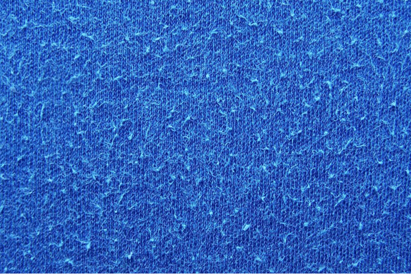 macro photo of pilling blue fabric