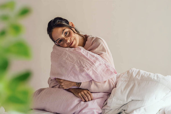 A woman hugging her comfortable bedding during the spring time