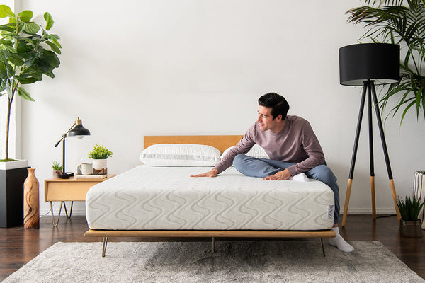 Man sitting on unmade foam mattress