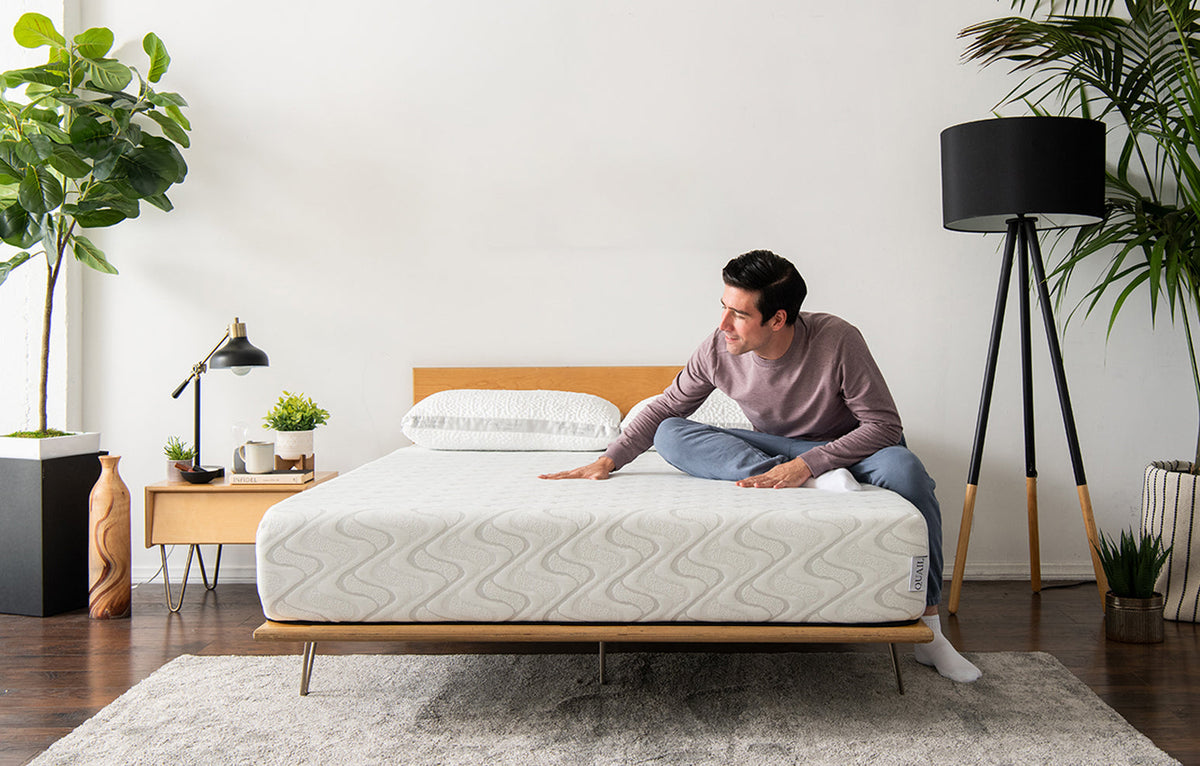 Man sitting on unmade foam mattress