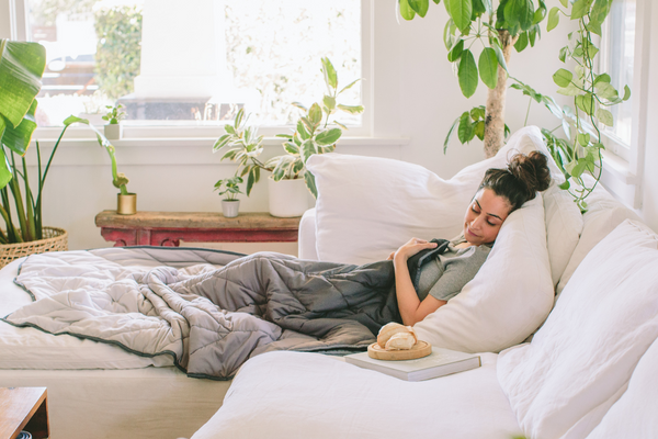 A woman relaxing on her bed during the day