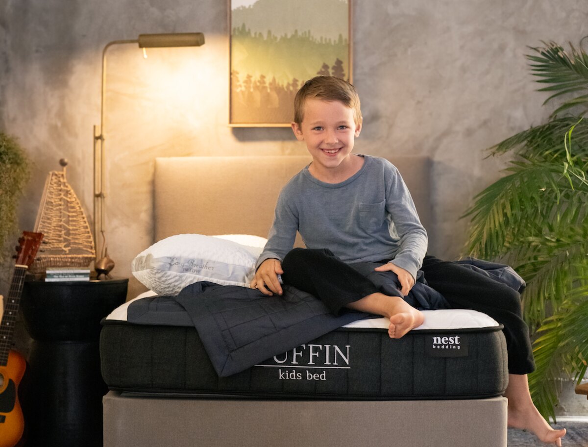 Young child smiling on a Puffin Kids Bed with Easy Breather Jr. Pillow