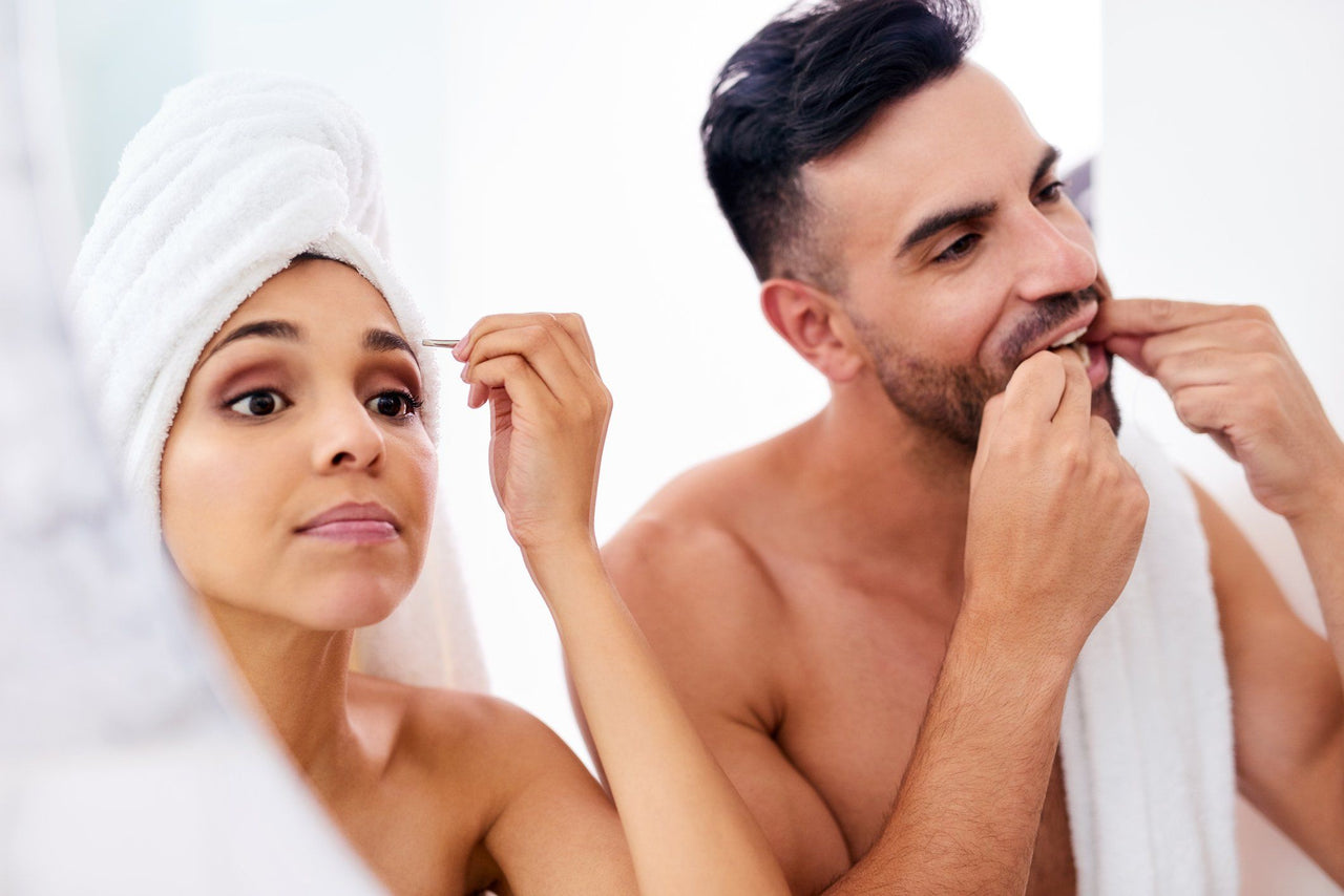 couple getting ready together in bathroom mirror