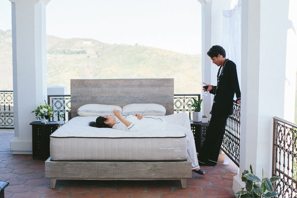 Couple hanging out in their beautiful airy bedroom
