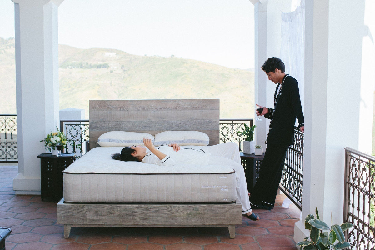 Couple hanging out in their beautiful airy bedroom