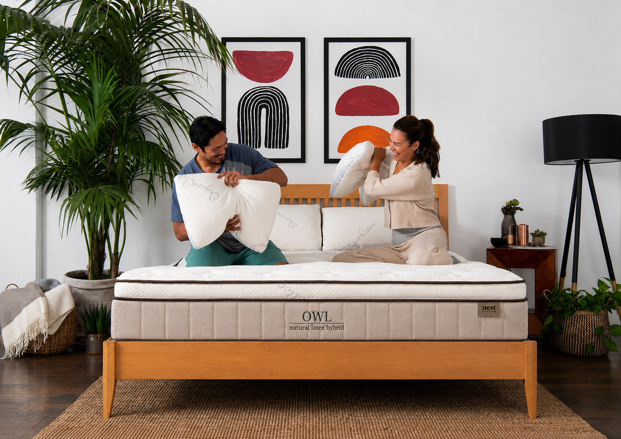 A couple playing on the owl mattress with pillows