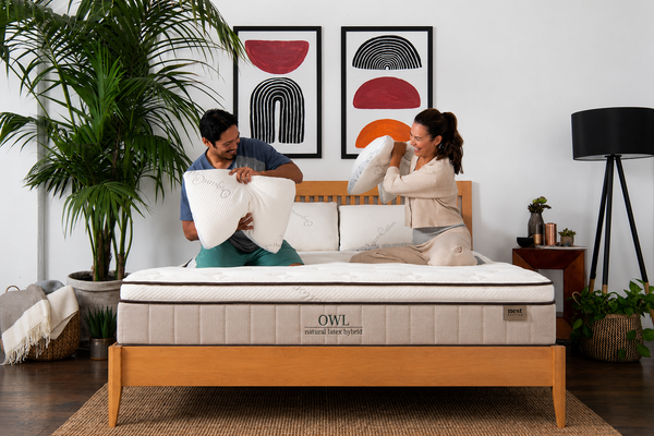 A couple playing on the owl mattress with pillows