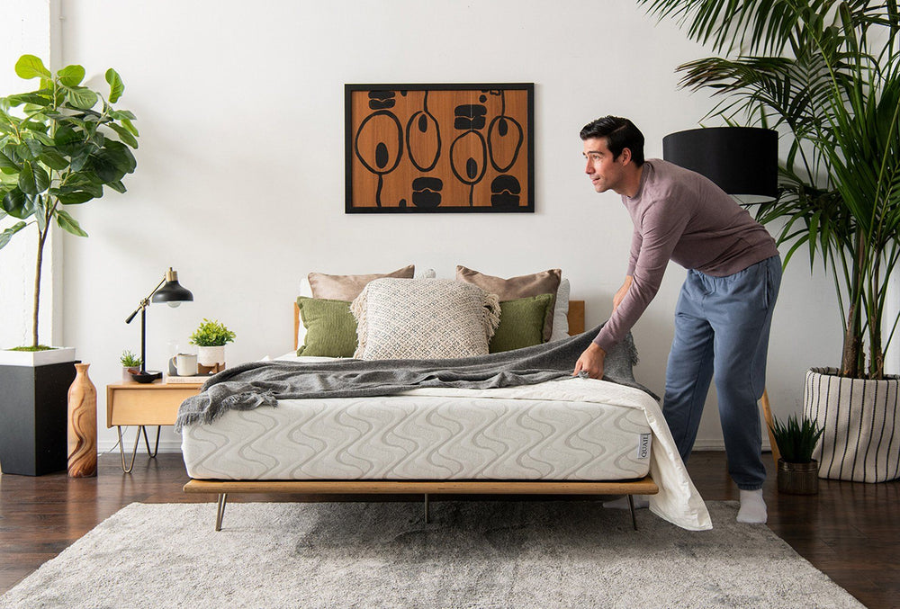 A man adjusting the bedding on the Quail mattress.