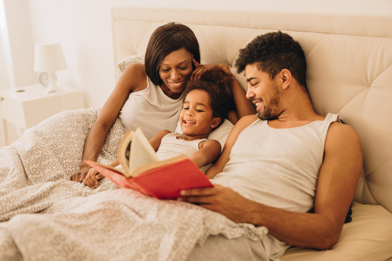 family reading bedtime stories together in bed