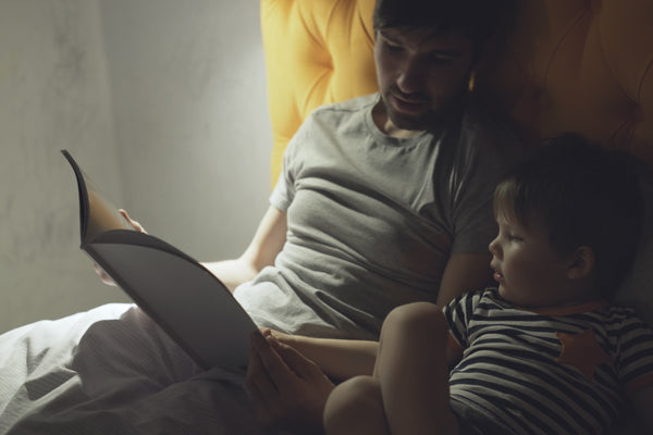 Father reading bedtime story to son which is the language of sleep