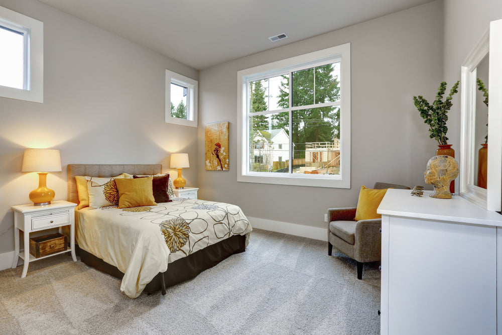 Neatly arranged bedroom with a bed, lamps, and decor.