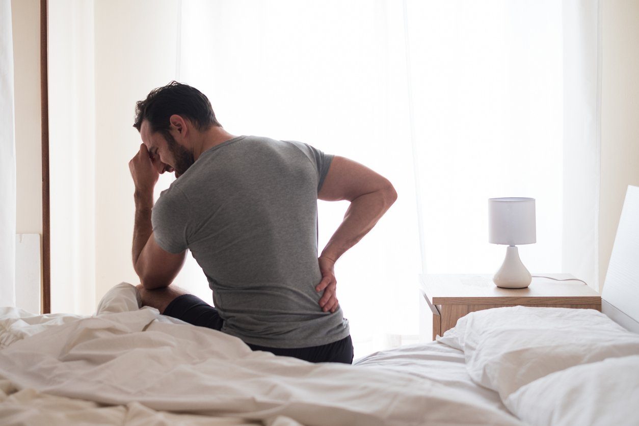 man waking up with back pain from mattress