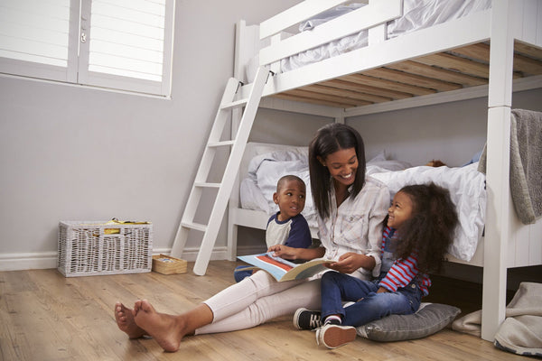 mother reading to her kids in kid's room with bunk beds