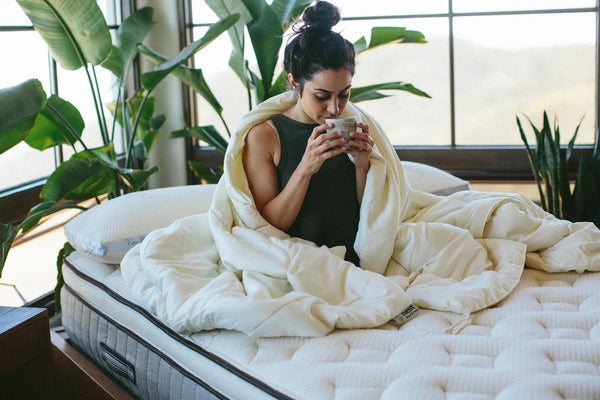 Woman drinking hot cup of tea in bed