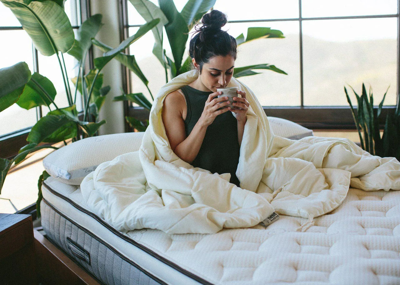 Woman drinking hot cup of tea in bed