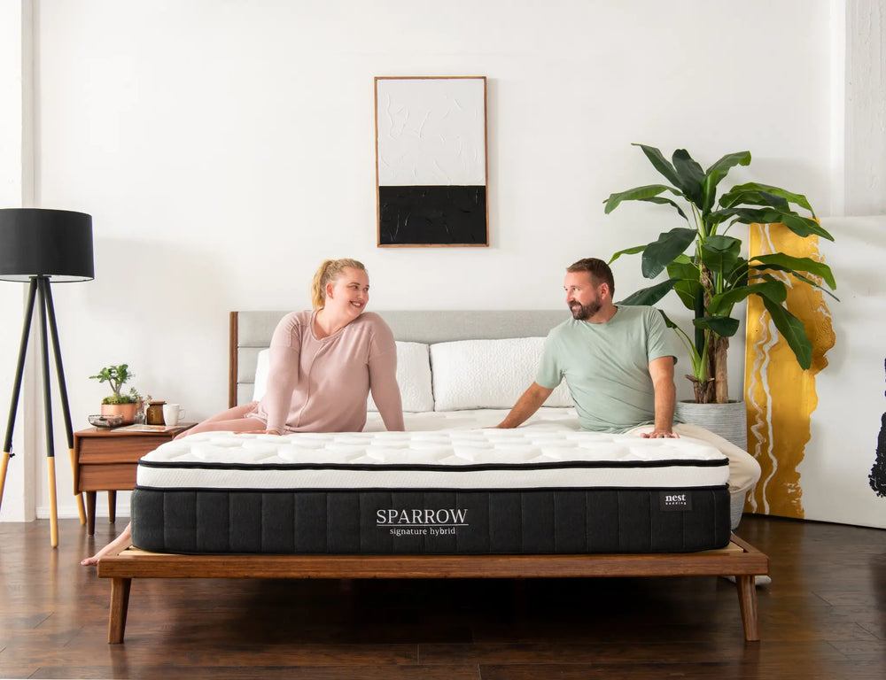 woman and man sitting on a sparrow mattress.