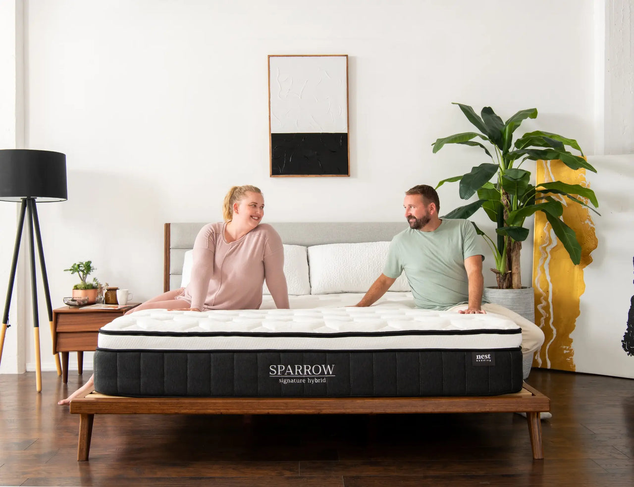 woman and man sitting on a sparrow mattress.