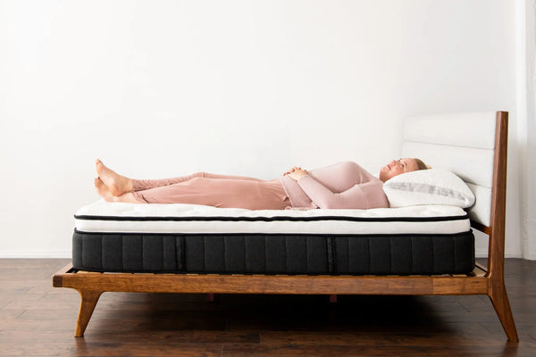 woman demonstrating the Sparrow mattress's back support for back sleepers