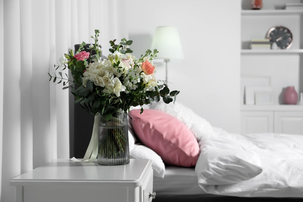 A vase of flowers set aside a comfy bed