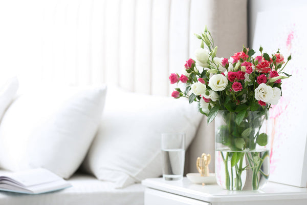 A vase of flowers set aside two comfortable pillows