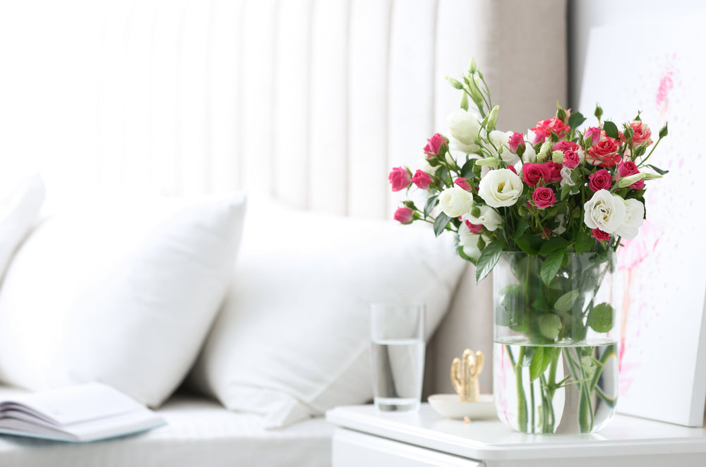 A vase of flowers set aside two comfortable pillows