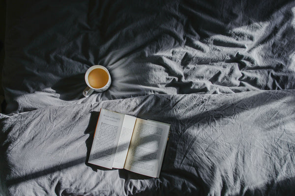 Drinking tea and reading a book for a nighttime routine