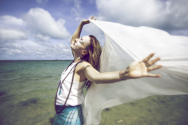 woman enjoying benefits of lucid dreaming by the ocean