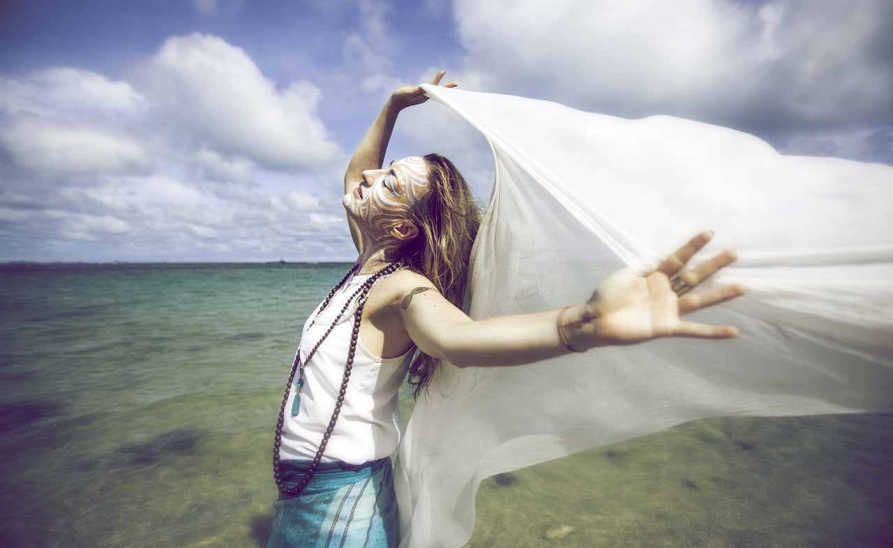 woman enjoying benefits of lucid dreaming by the ocean