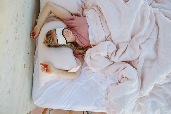 woman sleeping on nest bedding sheets during the summer time