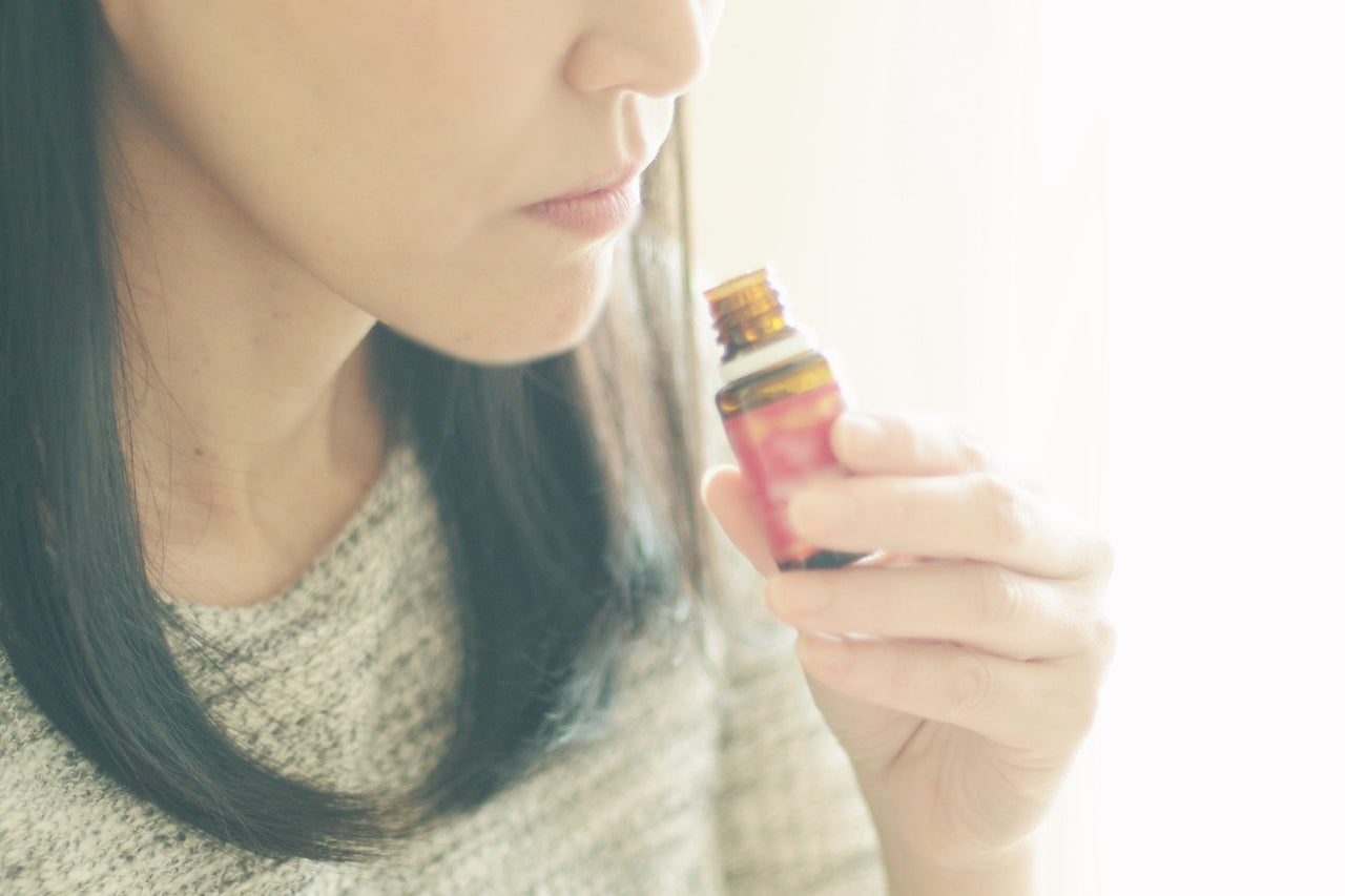 woman smelling essential oils to benefit from aromatherapy and sleep