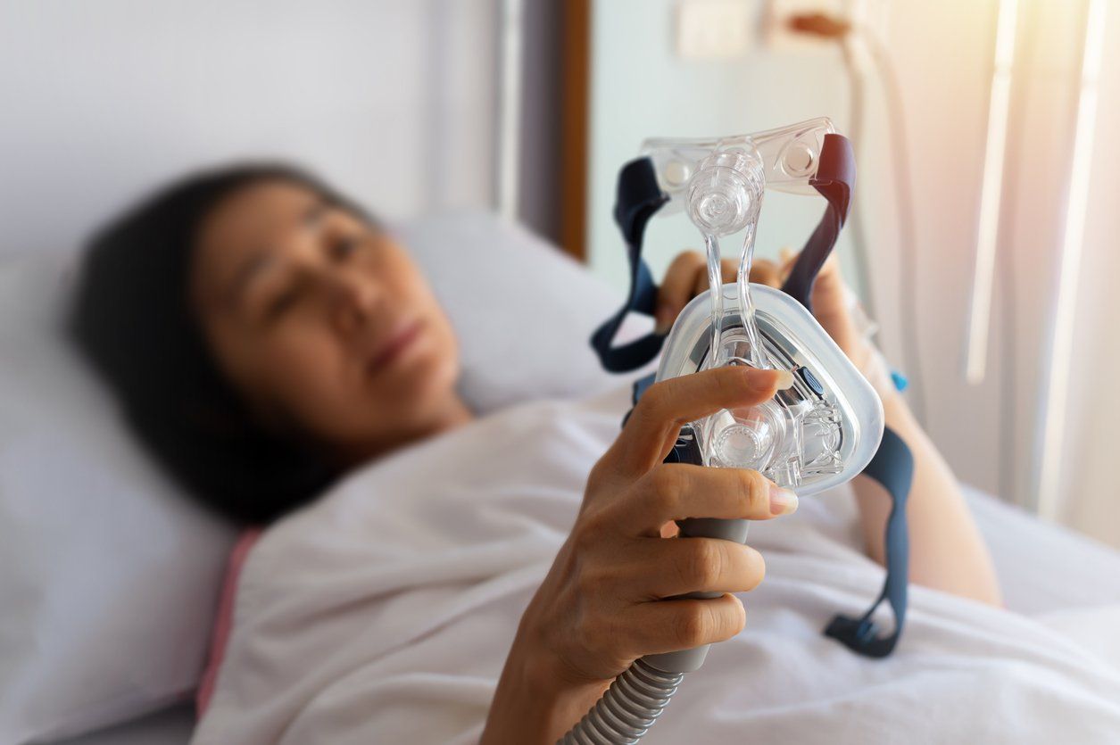 woman using CPAP machine for obstructive sleep apnea therapy
