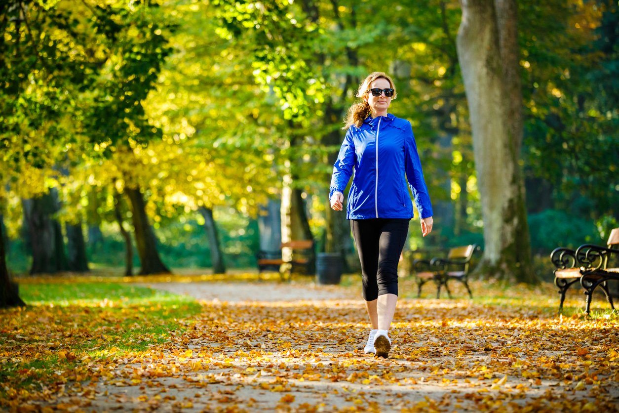 woman walking in a city park in the fall