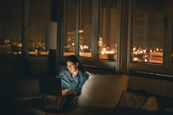 woman working on laptop in bed at night