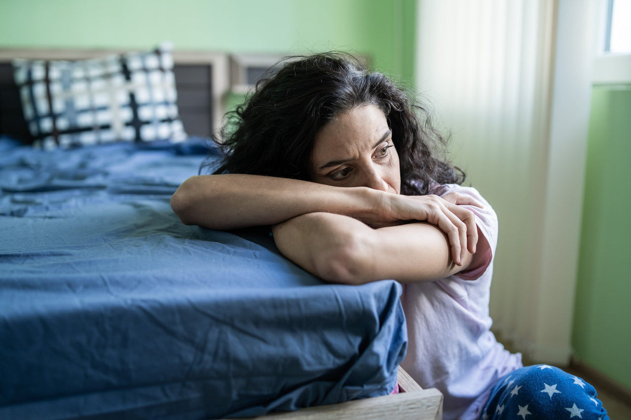 woman worried by bed suffering from sleep dread