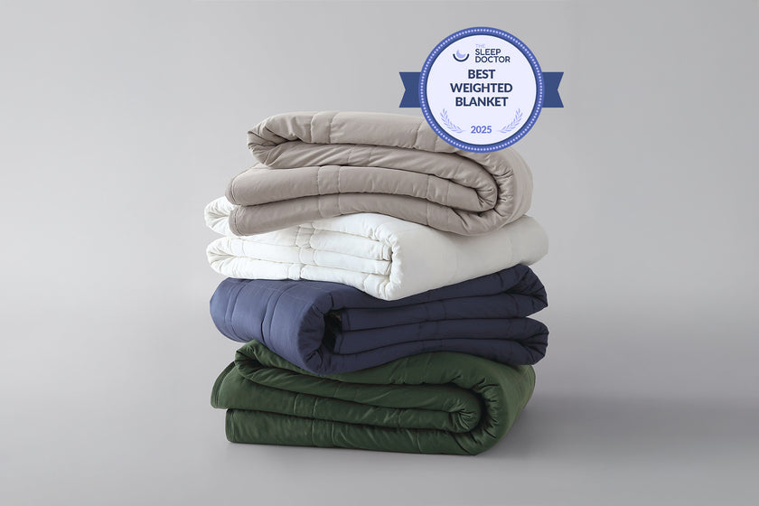 Stack of weighted blankets in various colors with a 'Best Weighted Blanket' award badge on a gray background